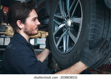 Auto Mechanic Working In Garage, Checking Wheels, Car Service Technician Repair Customer Car At Automobile Service Center, Inspecting Car Under Body And Suspension System, Vehicle Repair Service Shop