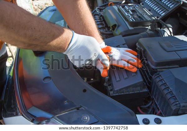 Auto mechanic working in garage. Repair\
service. Maintenance of automotive\
engine
