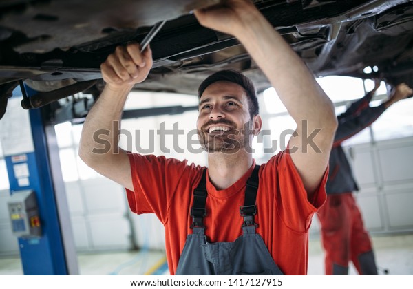 Auto mechanic
working in garage. Repair
service.