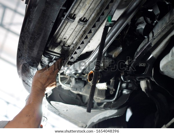 Auto mechanic\
working in garage. Repair\
service.