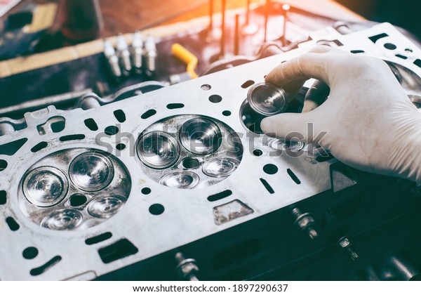 Auto mechanic working in garage. Repair
service.  opened automobile engine cylinder head for maintenance
repair at car service station for
diagnosis