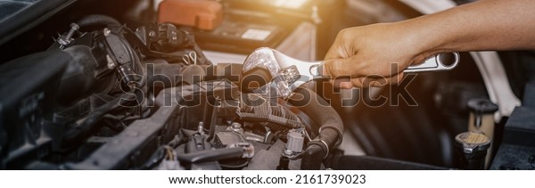 Auto mechanic working in garage. Repair\
service, Service car, Fixing automotive engine, car service and\
maintenance, Repair service, repairman hands repairing a car engine\
automotive workshop.