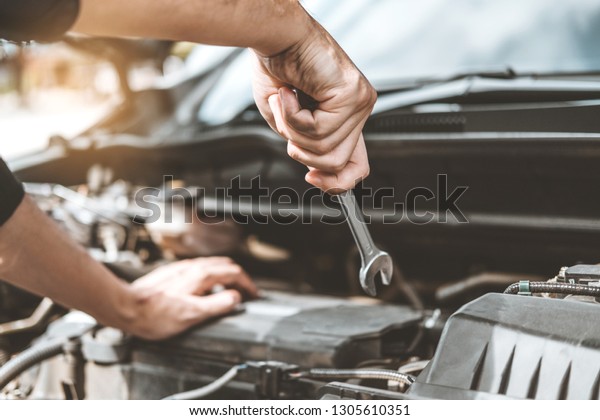 Auto\
mechanic working in garage Technician Hands of car mechanic working\
in auto repair Service and Maintenance car\
check.