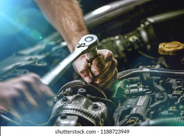 Auto mechanic working on car engine in mechanics garage. Repair service. authentic close-up shot