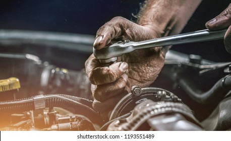 Auto mechanic working on car engine in mechanics garage. Repair service. authentic close-up shot - Shutterstock ID 1193551489
