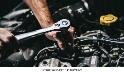 Auto mechanic working on car engine in mechanics garage. Repair service. authentic close-up shot - Shutterstock ID 1458396509