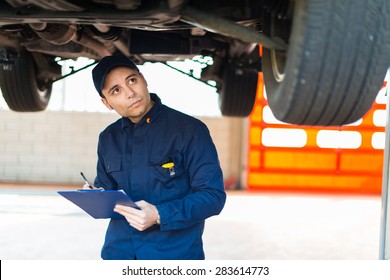 Auto mechanic working on a car in his garage