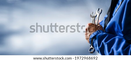 Auto mechanic working on car broken engine in mechanics service or garage. Transport maintenance wrench detial Wide banner or panorama photo.
