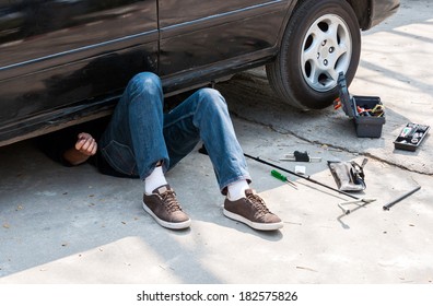 Auto Mechanic Working Under An Old Car.