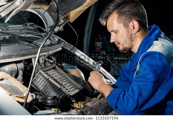 The auto mechanic works in the\
garage. Repair service. Maintenance of the car, car\
repair.