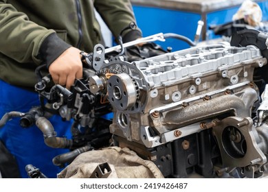 Auto mechanics assembling a disassembled car engine in a workshop - Powered by Shutterstock