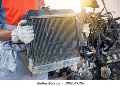 Auto Mechanics Holding Broken Car Radiator In Auto Service, Technician Doing The Checklist For Repair Car Engine In The Garage