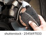 Auto mechanics replace worn brake pads to maintain a car braking system , Car maintenance concept