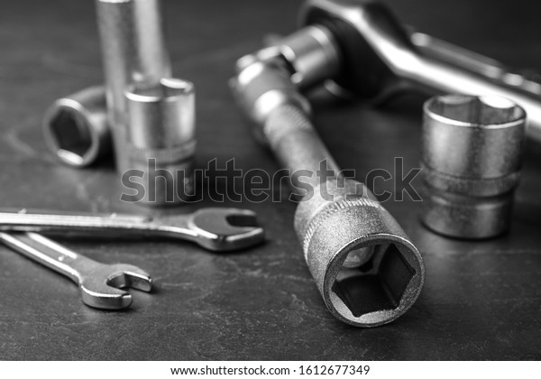 Auto\
mechanic\'s tools on grey background,\
closeup