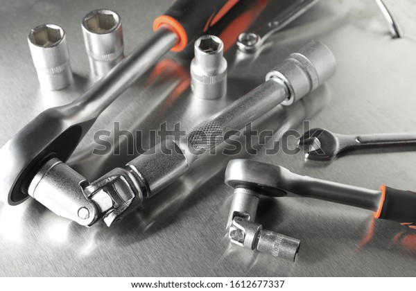 Auto\
mechanic\'s tools on metallic surface,\
closeup