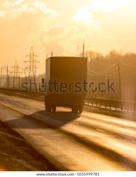 Auto on the road at\
sunset