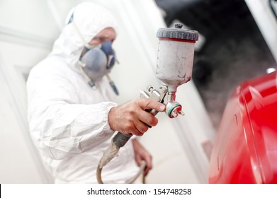 Auto painter spraying paint on a car body - Powered by Shutterstock