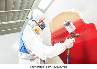 Auto Painting Worker. Red Car In A Paint Chamber During Repair Work