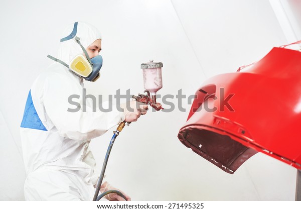 auto painting worker. red car in a paint chamber\
during repair work