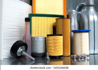 Auto parts accessories: oil filter, air filter, fuel filter, cabin filter, spark plugs and engine oil close-up on a steel background