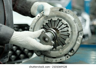Auto parts. Clutch kit close-up. An auto mechanic checks the technical condition of the drive disc, the driven disc and the exhaust bearing. Repair and maintenance in a car service. - Shutterstock ID 2101069528
