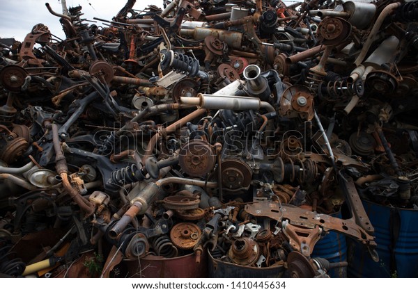 A lot of auto parts stacked\
in an unarranged order, at a car graveyard, in Kozani,\
Greece.