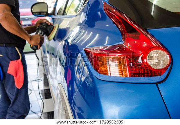 Auto polishing with\
machine.Blue car polish to remove and recover the car.Focus on car\
tail lights