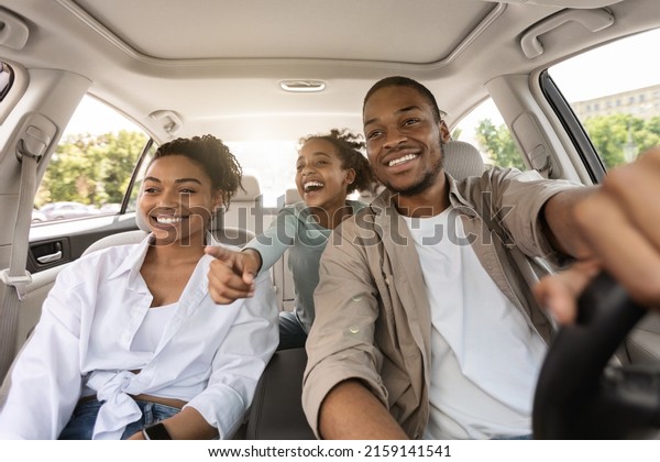 Auto\
Purchase. Joyful Black Family Having Road Trip Sitting In New Car\
Enjoying Summer Weekend Together. Parents And Daughter Riding\
Across City Traveling By Automobile. Selective\
Focus
