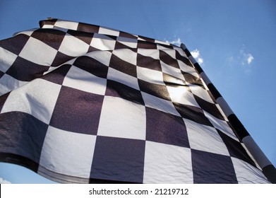 Auto racing checkered flag on a background of the  blue sky.