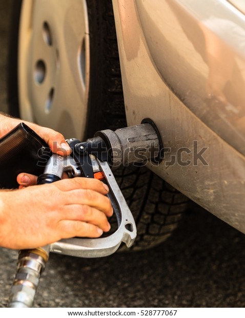 Auto refuel. Car at gas\
station being filled with fuel, fill up of liquefied petroleum gas,\
LPG
