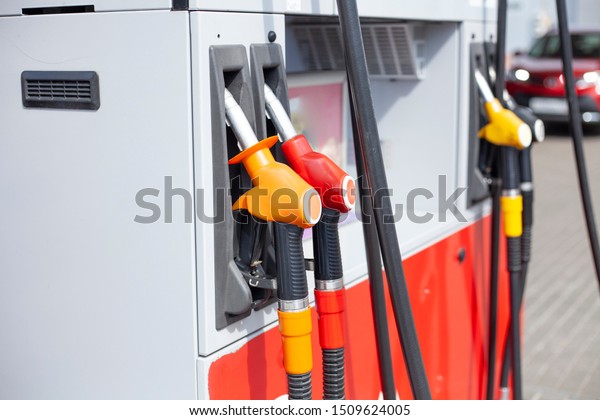 Auto\
refueling. Gas station for refueling a car with fuel. Hoses for\
supplying gasoline to the gas tank of the\
machine.