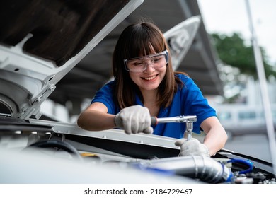 Auto Repair Concept. Asian Woman Car Mechanic Wearing Watercolor Shirt In Garage. Happy Female Mechanic In Car Repair Cente