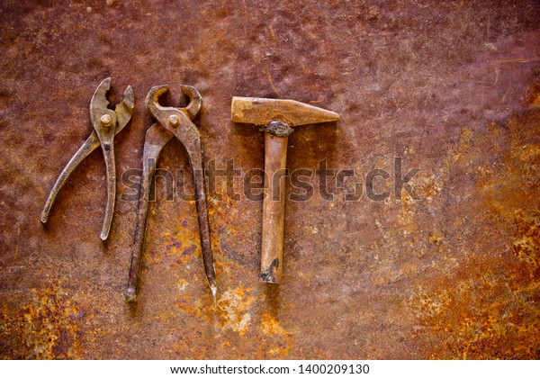 Auto repair shop concept, repair of cars,\
motorcycles. Old pliers, hammer and cutter on a rusty iron sheet.\
Craftsman tool, for man\
worker