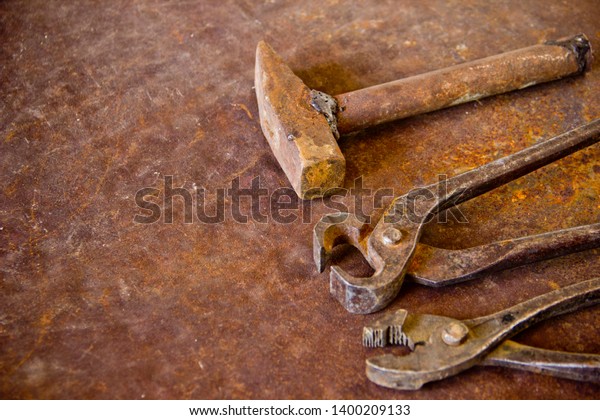 Auto repair shop concept, repair of cars,\
motorcycles. Old pliers, hammer and cutter on a rusty iron sheet.\
Craftsman tool, for man\
worker