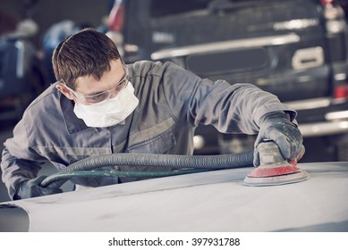 auto repairman grinding autobody bonnet 