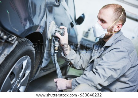 auto repairman grinding automobile car body