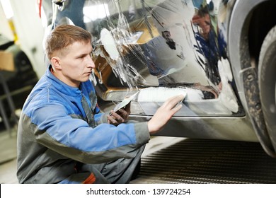 Auto Repairman Worker In Automotive Industry Examining Car Body Painting Or Repaint At Auto Repair Shop