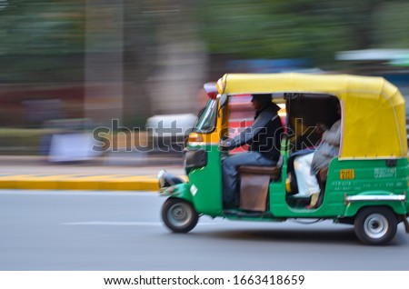 Auto rickshaws are a popular mode of transportation in India for last mile travel. The photograph shows the panned shot of an Auto speeding on the road