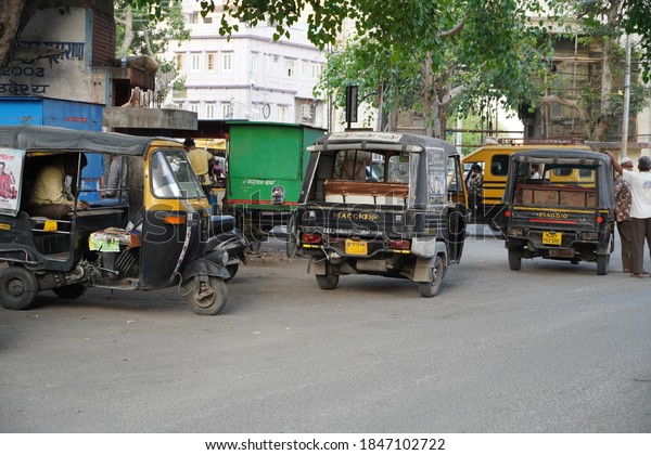 Auto rickshaws waiting\
for customers, parked at the side of the street. Udaipur India -\
August 2020 WWM
