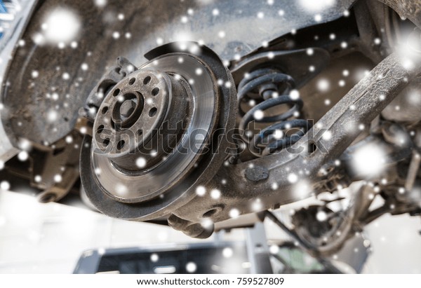 auto service and maintenance concept - car
brake disc at repair station over
snow