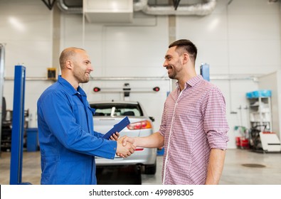 Auto Service, Repair, Maintenance, Gesture And People Concept - Mechanic With Clipboard And Man Or Owner Shaking Hands At Car Shop