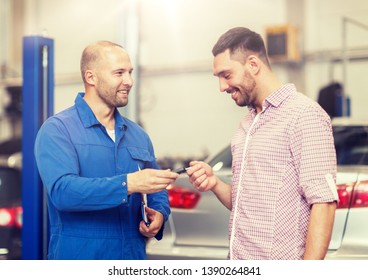 Auto Service, Repair, Maintenance And People Concept - Mechanic With Clipboard Giving Key To Happy Smiling Man Or Owner At Car Shop