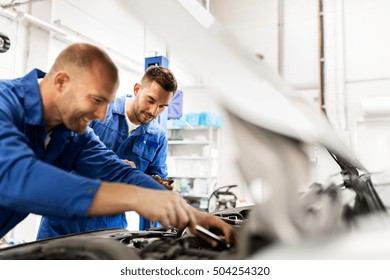 Auto Service, Repair, Maintenance And People Concept - Mechanic Men With Wrench Repairing Car At Workshop