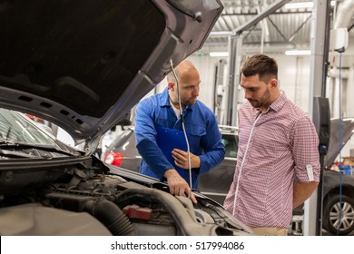 Auto Service, Repair, Maintenance And People Concept - Mechanic With Clipboard Talking To Man Or Owner At Car Shop