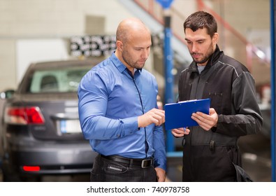 Auto Service, Repair, Maintenance And People Concept - Mechanic With Clipboard And Customer Or Car Owner At Workshop