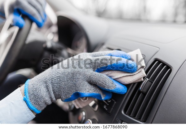Auto service staff hand\
cleaning car interior with microfiber cloth. Car detailing and\
valeting concept