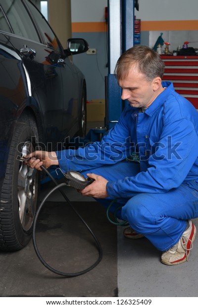 Auto Service\
Technician Checking Tire\
Pressure