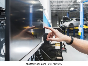 Auto Service Technician Looking For Car Parts On His Computer Inside Vehicles Service Area. Automotive Computer.