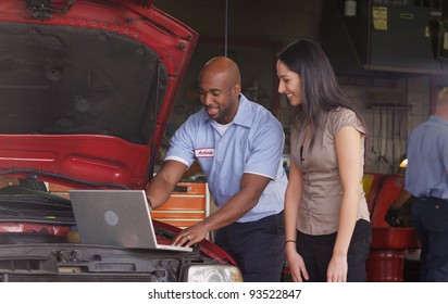 Auto shop mechanic working on laptop computer with customer - Powered by Shutterstock