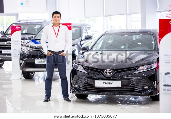 Auto showroom. Toyota brand cars are in a row,\
polished beautiful modern cars with a shiny surface reflecting\
beautiful light illumination in the hall. Copy space. Shymkent\
Kazakhstan April 15, 2019